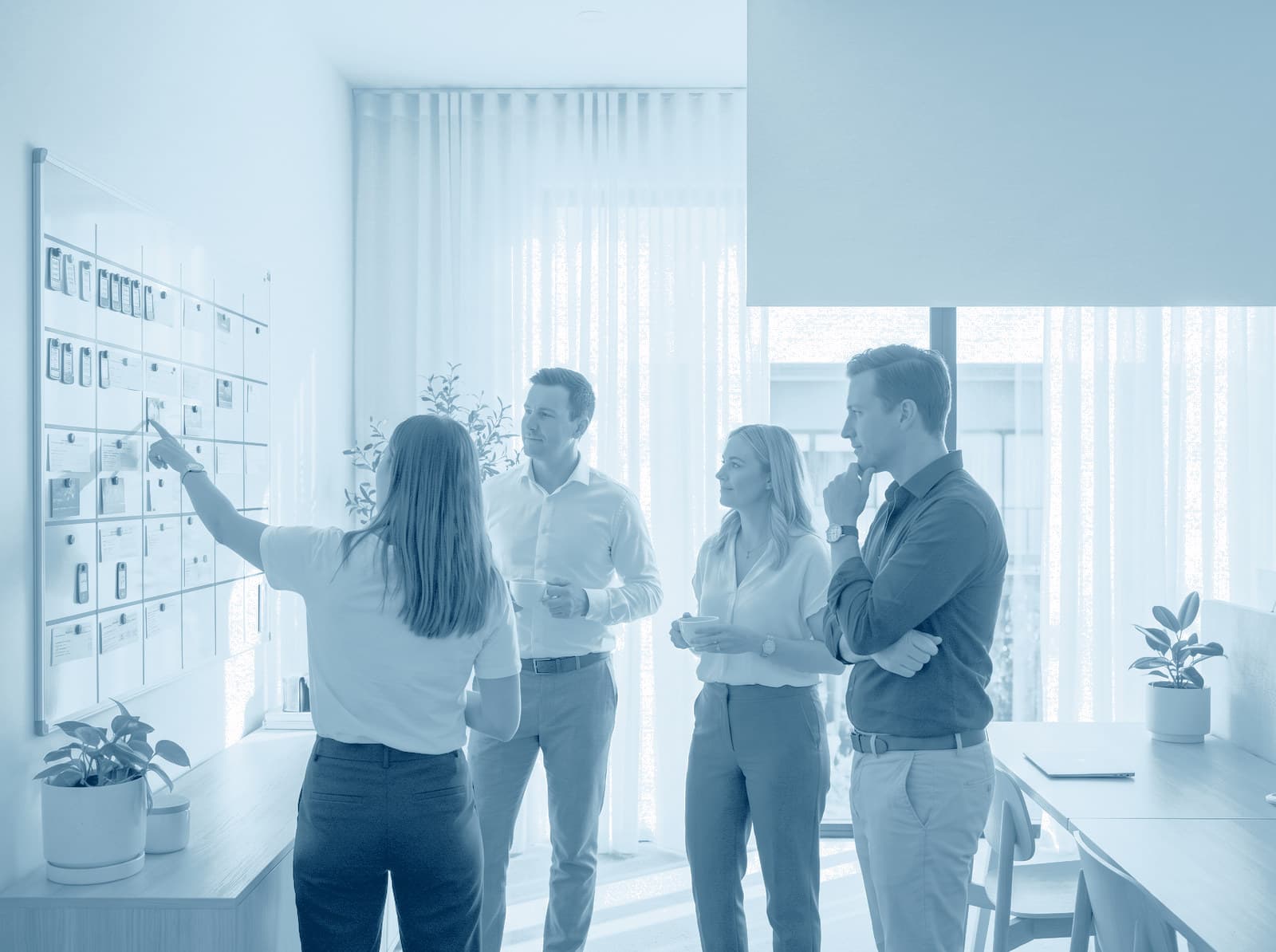 Un equipo de gestión planifica la semana en un gran planificador de pared